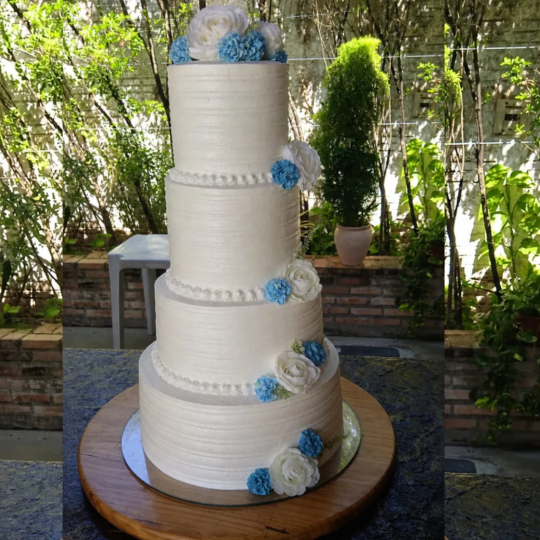 Bolo de casamento de quatro andares com flores azuis e brancas
