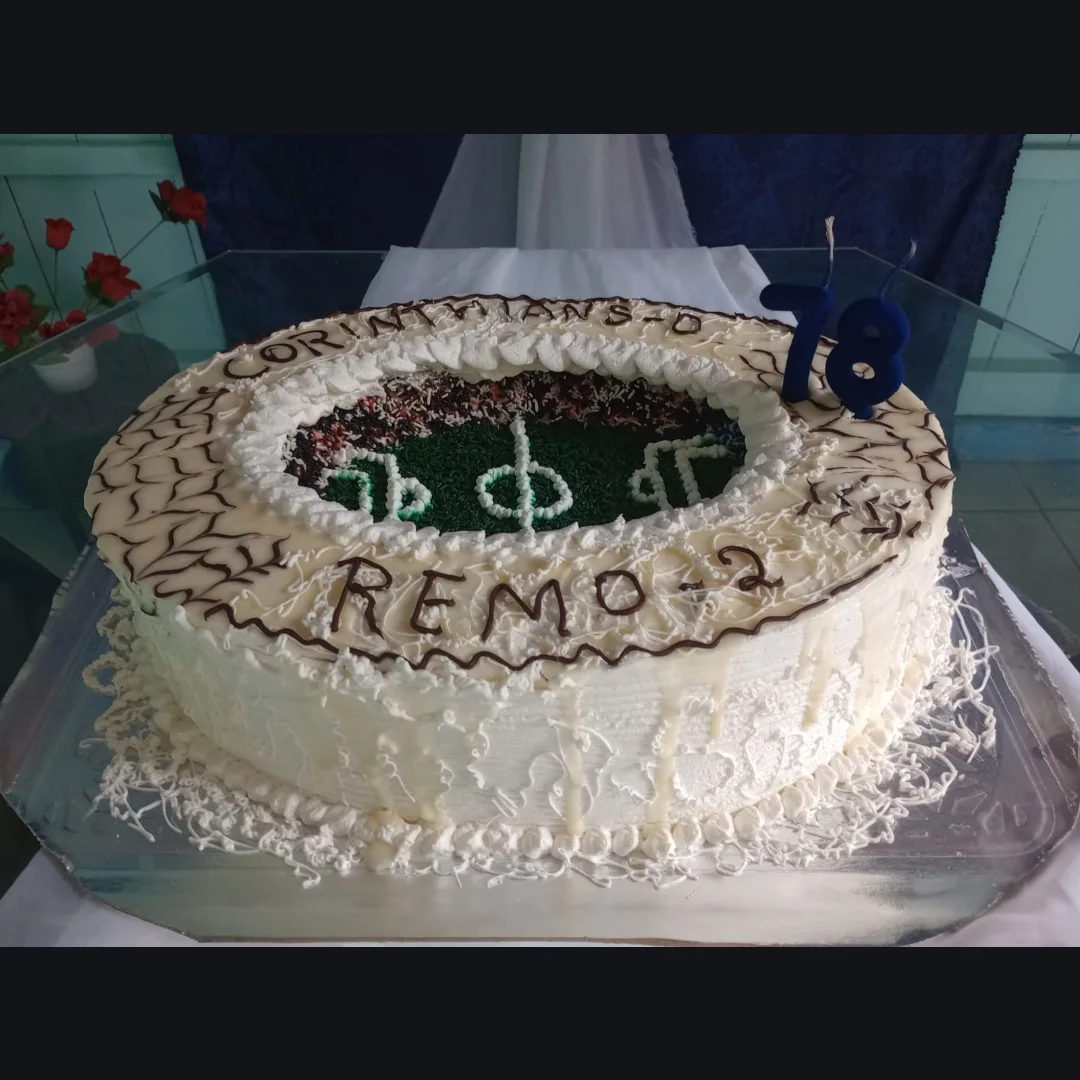 Bolo de aniversário decorado como campo de futebol, com placar escrito em chocolate